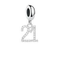 Silver number ā21āā charm.