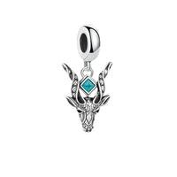 Silver charm with turquoise gemstone.