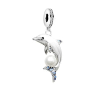 Silver dolphin charm with pearl and blue accents.