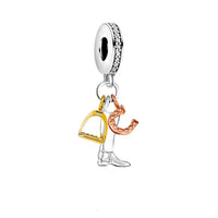 Silver charm with gold stirrup, rose gold horseshoe, and silver boot.