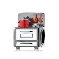 Silver stove charm with red pot.