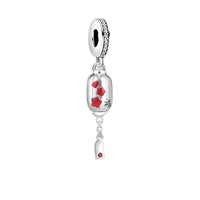 Silver charm with red floral accents.