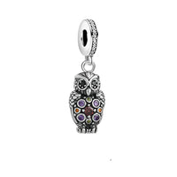 Silver owl charm with colorful gemstones.