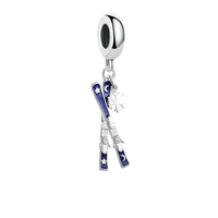 Silver charm with skis and snowflake.