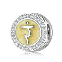 Silver charm with yellow symbol and crystal accents.