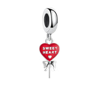 Silver charm with red heart and bow.
