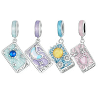 Four tarot card-themed charm pendants.