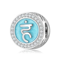 Silver charm with blue symbol and crystal accents.
