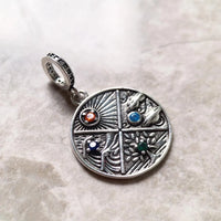 Silver charm with colorful gemstones.
