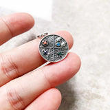 Silver pendant with four-season design.