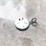 Round silver pendant with black accents.