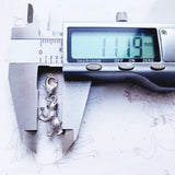 Silver bear charm being measured.