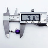 Purple pearl pendant being measured.
