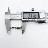 Caliper measuring a small alligator charm.