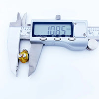 Digital caliper measuring a gold charm.