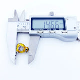 Yellow and silver charm being measured.