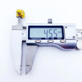Gold-colored jewelry measured by calipers.