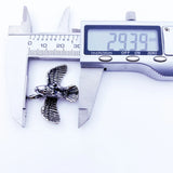 Metal bird pendant being measured.