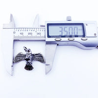 Eagle pendant being measured.