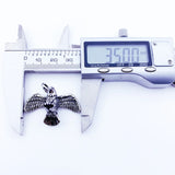 Eagle pendant being measured.