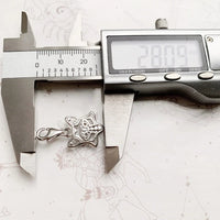 Silver star charm being measured.