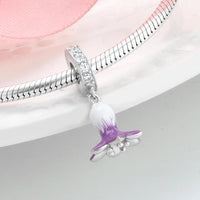 Silver charm bracelet with purple and white flower pendant.