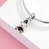 Teddy bear charm with black hat and suit.
