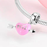 Pink heart-shaped charm with silver arrow.