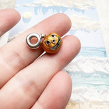 Orange jack-o’-lantern charm.