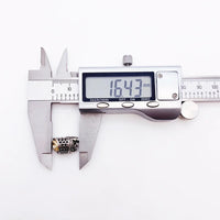 Digital caliper measuring a decorative metal bead.