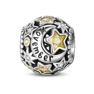 Silver charm with yellow stars and moon.
