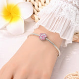 Silver charm bracelet with pink clover.