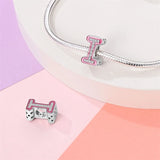 Pink and silver letter ’I’ charm.