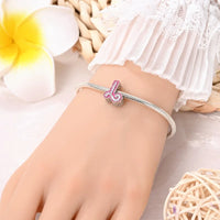 Silver charm bracelet with pink letter ’J’.