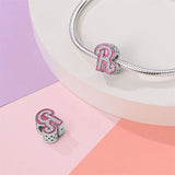 Silver charm bracelet with pink letter R.
