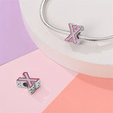 Pink and silver letter X charm.