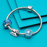 Silver charm bracelet with blue and white charms.