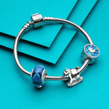 Silver charm bracelet with blue accents.