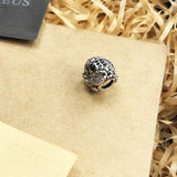Silver frog charm with black stones.