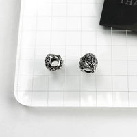 Two silver lion head beads.