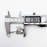 Crab-shaped pearl pendant being measured.