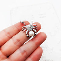 Crab-shaped pendant with pearl and rhinestones.