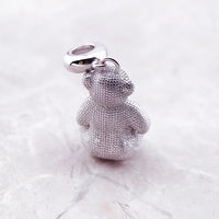 Silver teddy bear charm.