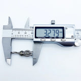Silver knot pendant being measured.
