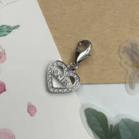 Silver heart charm with ’Sister’ inscription.