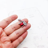 Silver snake and red apple charm.