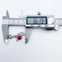 Snake charm bracelet being measured.