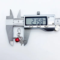 Snake and apple charm being measured.