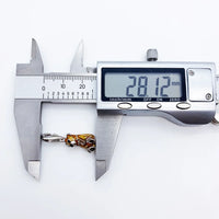 Digital caliper measuring a tiger pendant.