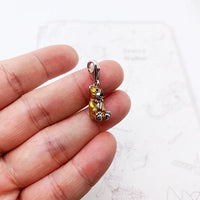 Gold and silver teddy bear charm.